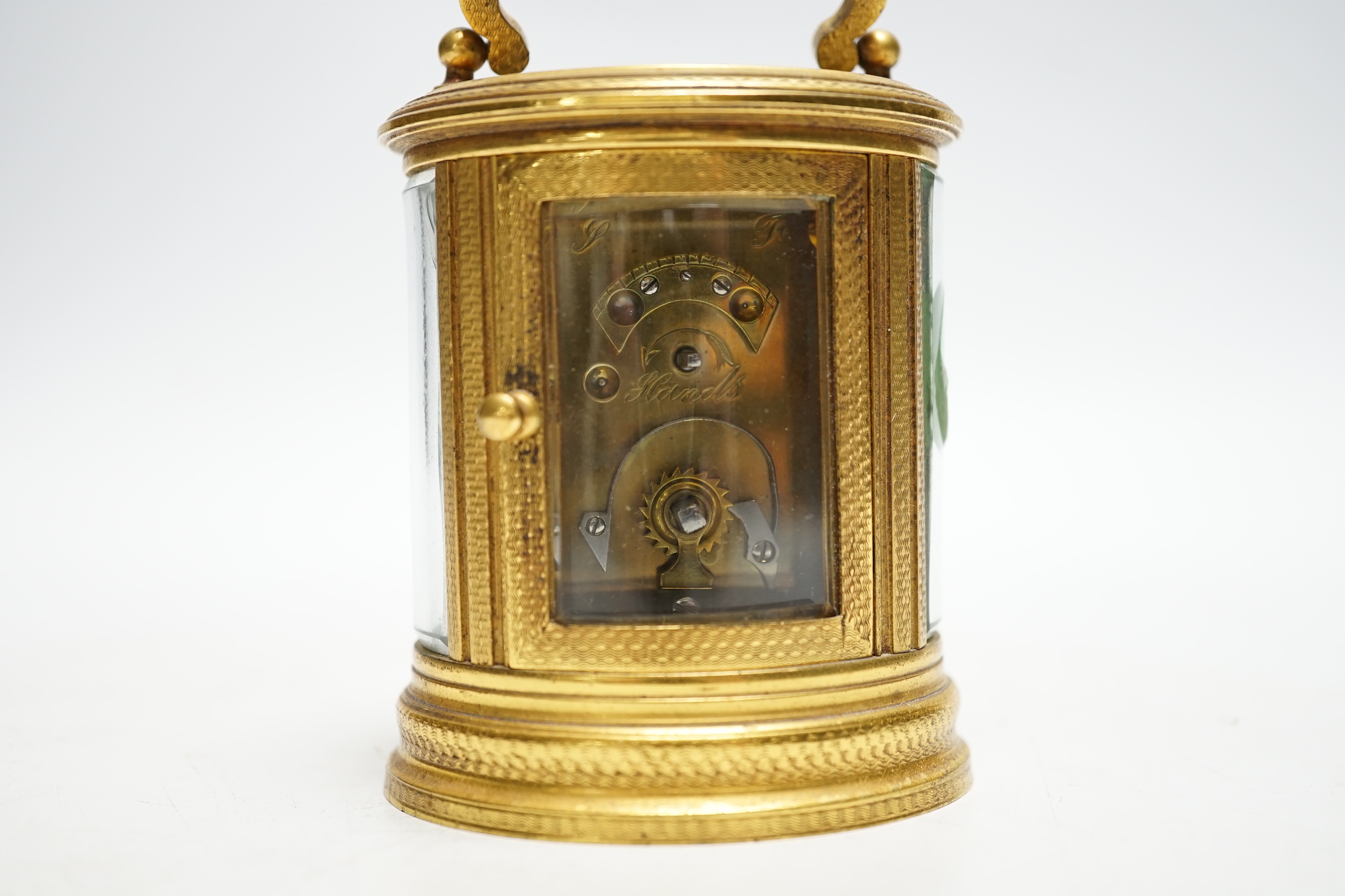 A late 19th French miniature engraved oval cased carriage timepiece, height 7cm